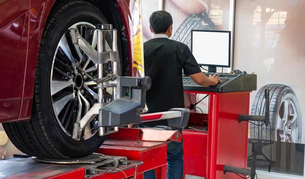 Wheel alignment being performed on a car in an automotive service shop.