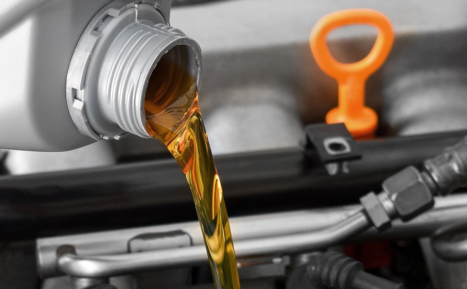 Engine oil being poured into a vehicle engine.